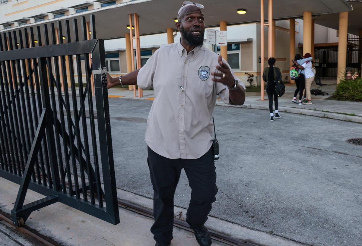 At Miami Carol Senior High School in Miami Gardens, Security guard Tony, who greeted several students by name, begins the process of closing the security gate as students greet one another.