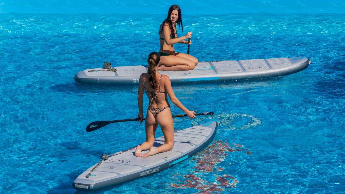 Paddleboarders demonstrate paddle boards at a booth during the opening day of the 2025 Discover Boating Miami International Boat Show at the Miami Beach Convention Center, on Wednesday, Feb. 12, 2025.