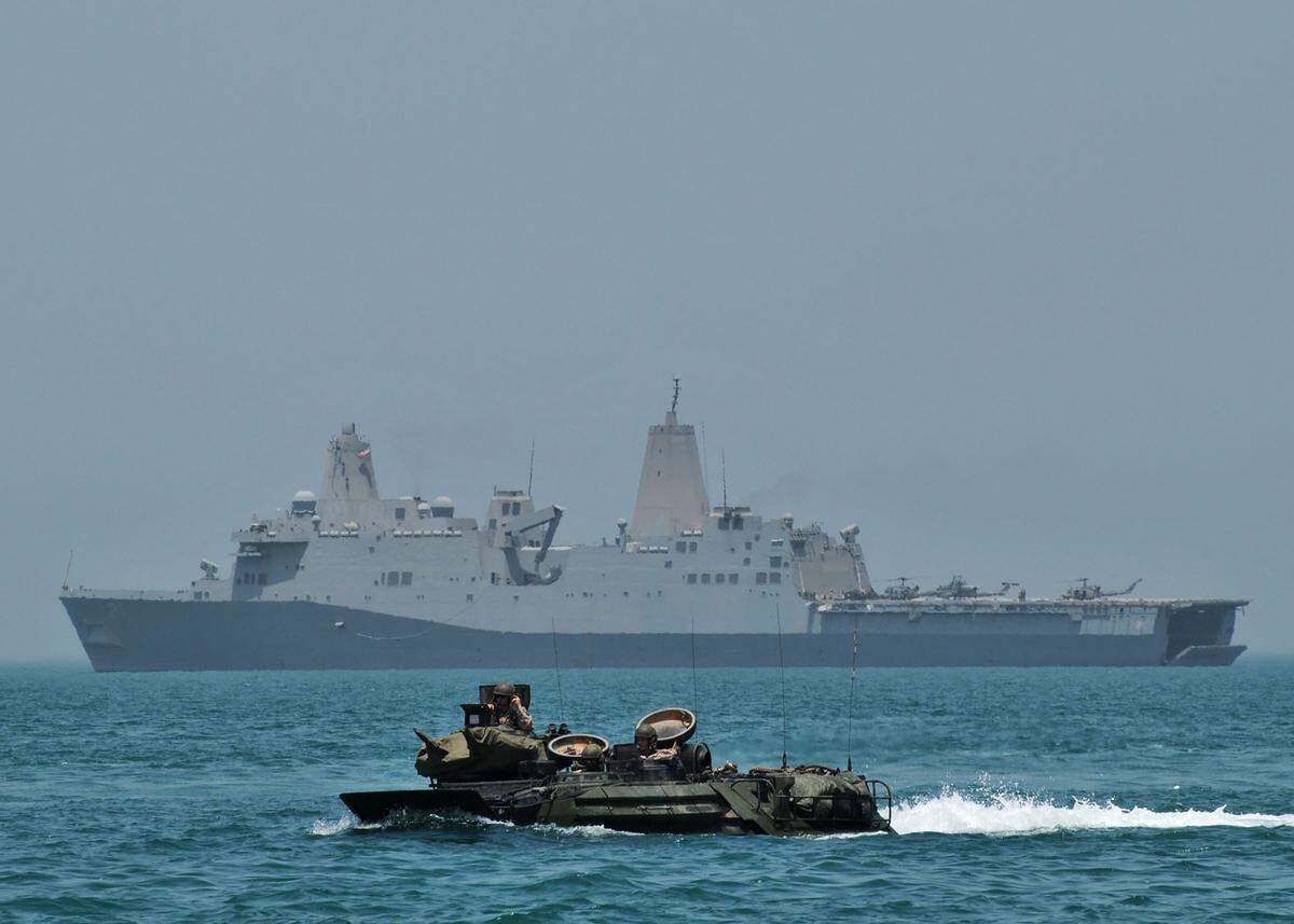 Marines pilot an amphibious assault vehicle with the amphibious transport dock ship USS New York (LPD 21) in the background while operating in the Arabian Sea. New York is deployed in support of maritime security operations and theater security cooperation efforts in the U.S. 5th Fleet area of responsibility.