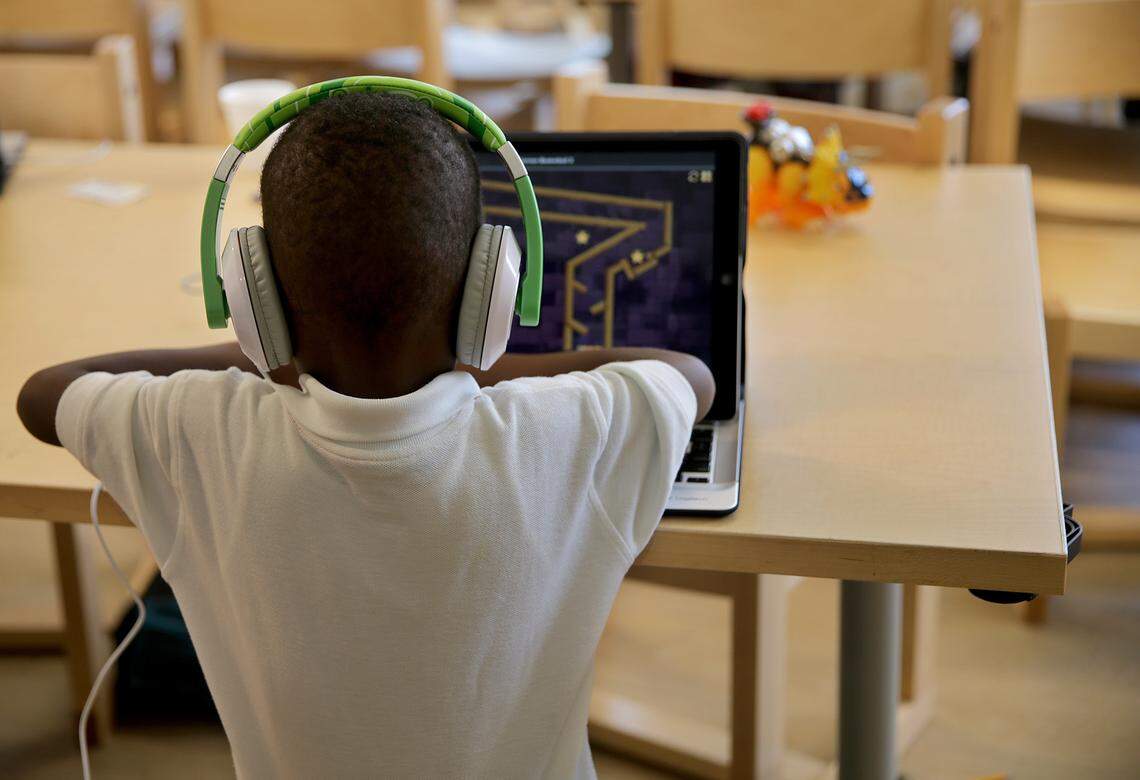 A child plays at a computer in one of the spaces dedicated to kids at the new Lotus House shelter for homeless women and children in Overtown.  The $25 million-project, which opens Thursday, will house a medical clinic, Yoga studio, a Zen garden and accommodate  490 women and children.