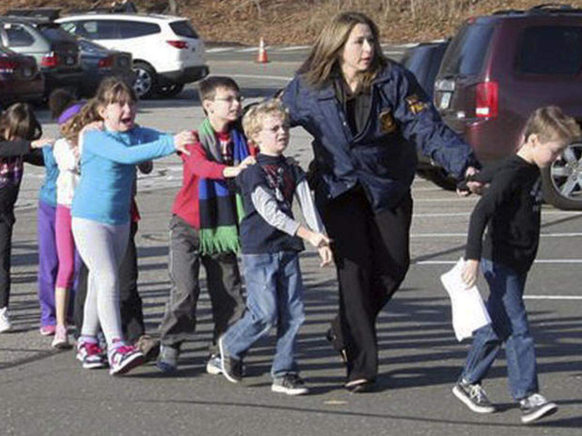 Students who survived the rampage at Sandy Hook Elementary School on Dec. 14, 2012, are led to safety.