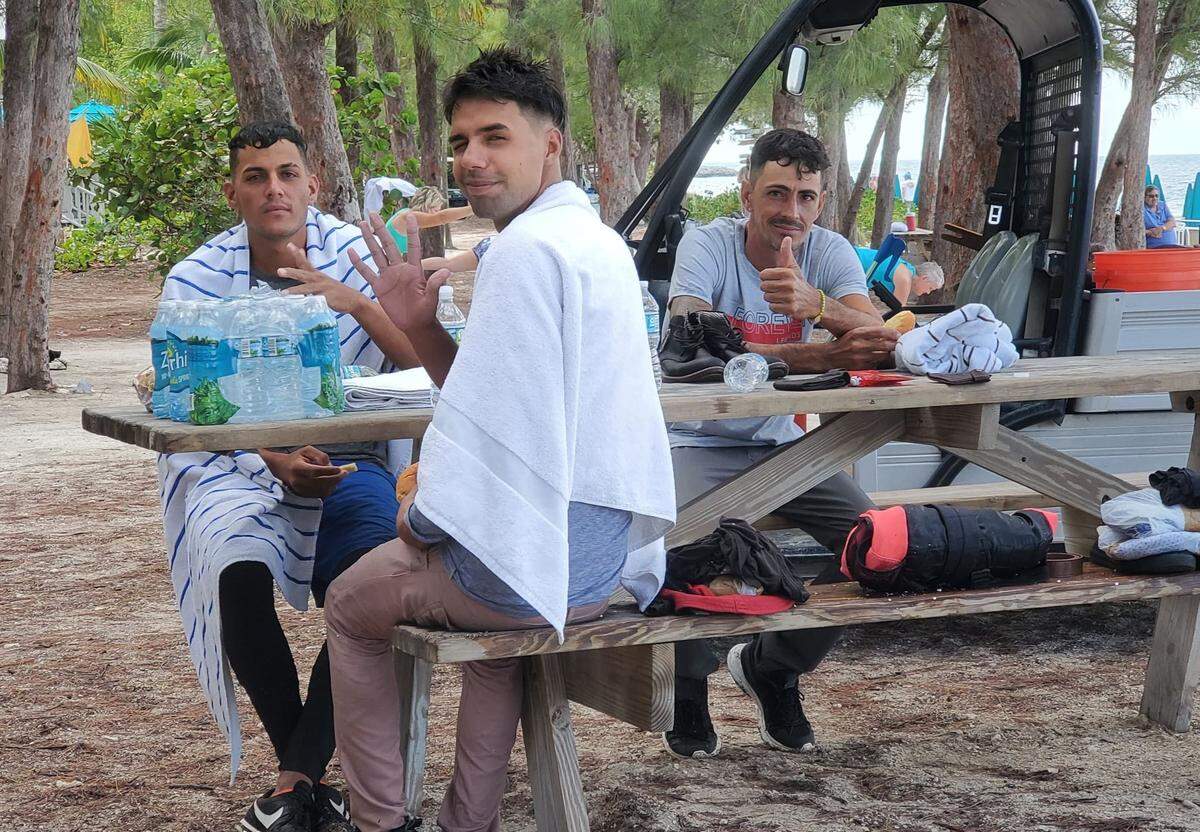 A group of Cuban migrants sit at a picnic table at Fort Zachary Historic State Park in Key West on May 30, 2022, after making landfall in a boat.