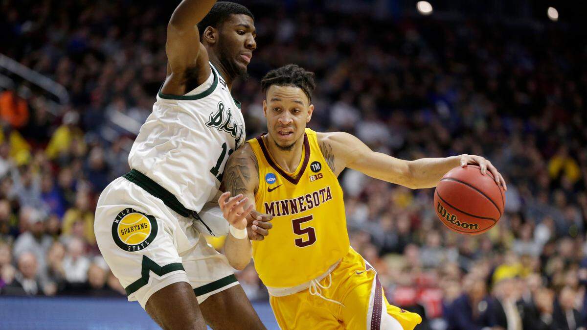 Minnesota’s Amir Coffey (5) drives past Michigan State’s Aaron Henry (11) during the first half of a second round men’s college basketball game in the NCAA Tournament, in Des Moines, Iowa, Saturday, March 23, 2019.