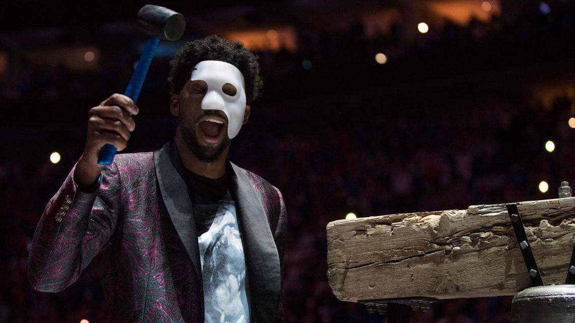 Philadelphia 76ers' Joel Embiid comes out in a "Phantom of the Opera" mask as he rings a Liberty Bell replica before Game 1 of the team's first-round NBA basketball playoff series against the Miami Heat, Saturday, April 14, 2018, in Philadelphia.