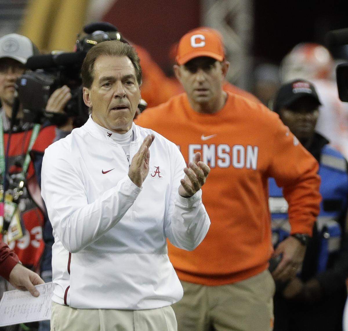 Alabama head coach Nick Saban and Clemson head coach Dabo Swinney watch warm ups before the NCAA college football playoff championship game Monday, Jan. 7, 2019, in Santa Clara, Calif.