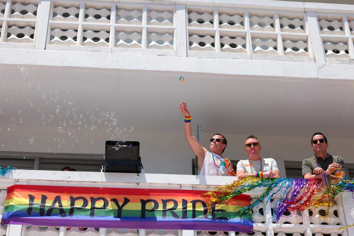 Aman throws a bracelet from a balcony to people parading on Ocean Drive during the 18th annual pride parade in Miami Beach, Florida, Sunday, April 12, 2026. 