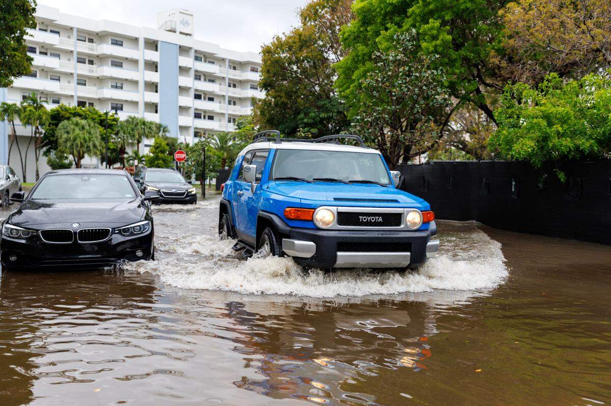 Cars go through the flooded road cause by heavy rains at North Bay Rd and 179th Dr. in Sunny Isles Beach on Wednesday, April 25, 2023.