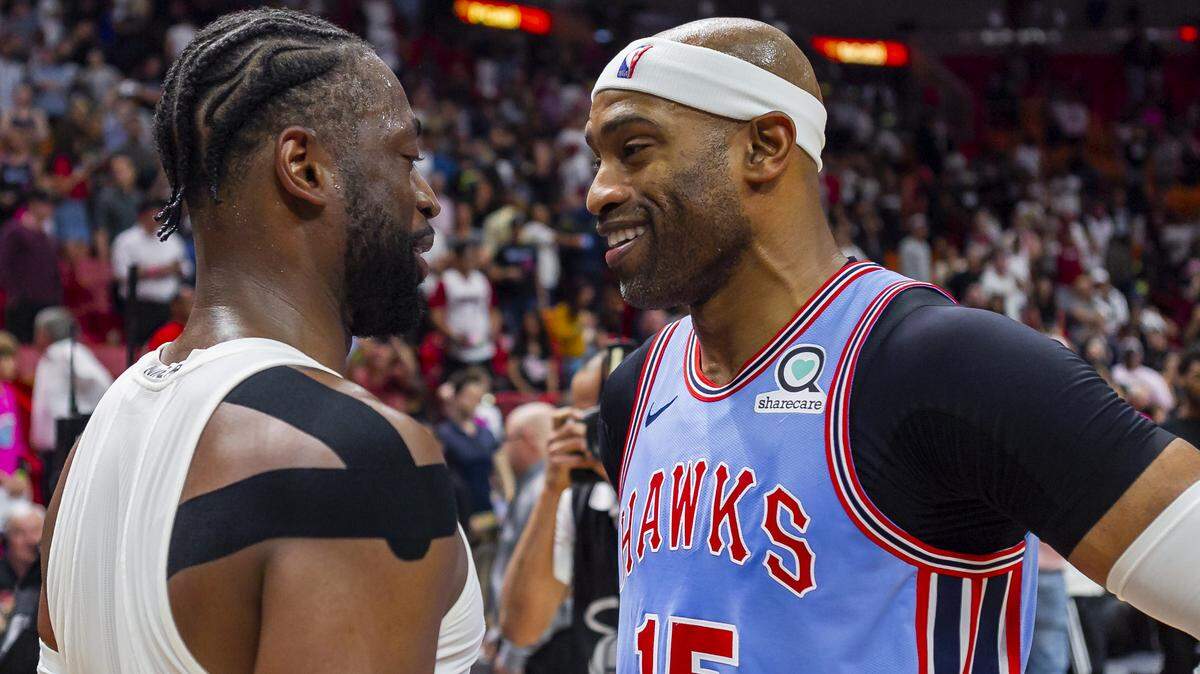 Dwyane Wade, del Heat (3), habla con el delantero de los Hawks Vince Carter (15) tras el triunfo de Miami este lunes en el American Airlines Arena.