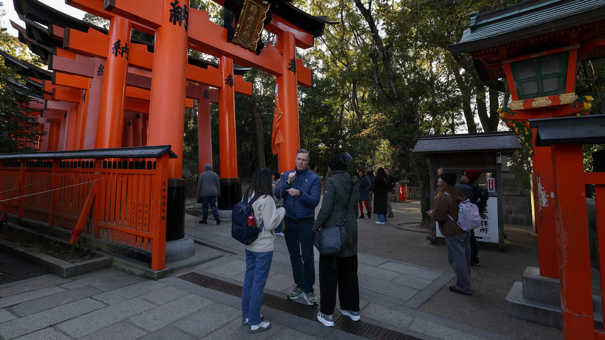 A foreign tourist talks with his tour guide at Fushimi Inari-Taisha Shrine, one of Japan’s most popular tourist destinations on January 21, 2026 in Kyoto, Japan.