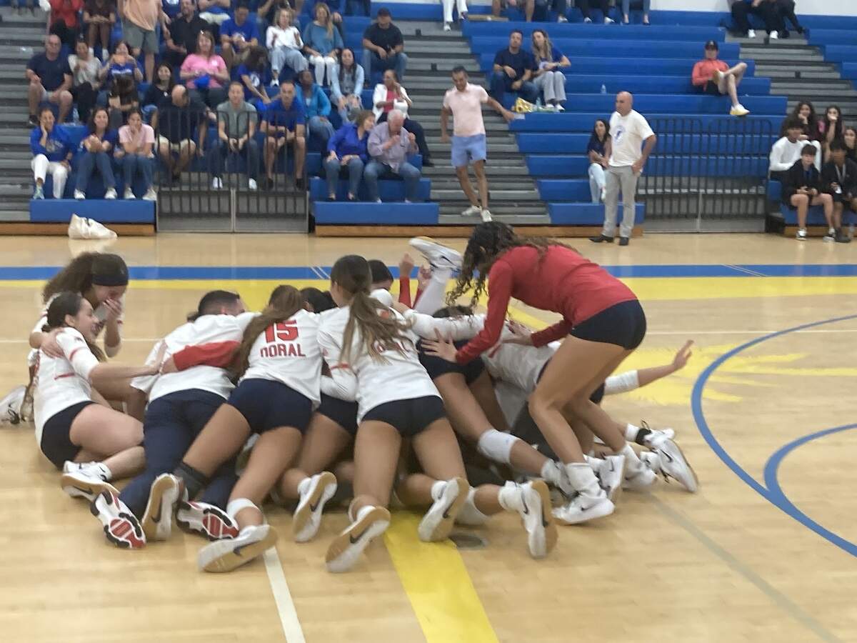 Doral Academy girls’ volleyball players pile up on the court at Cypress Bay High in Weston, Fla. on Wednesday night after beating the Lightning to win the Region 4-7A title.