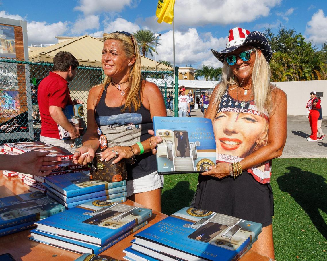 Supporters Nicolle Durie, left, and Sue Breitweiser of Key West, buy a book about former President Donald Trump as they enter the venue ahead of his late-night appearance at the Ted Hendricks Stadium at Henry Milander Park in Hialeah, on Wednesday, November 8, 2023.