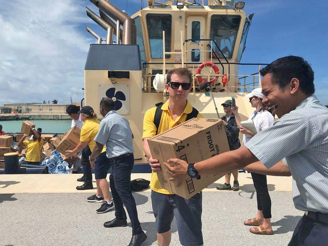 Members of the Royal Caribbean GoTeam help unload supplies from the Empress of the Seas cruise ship at the Port of Freeport, Bahamas, on Thursday. Tugboats ferried pallets of water bottles, boxes of cereal and 10,000 hot and cold meals from the ship to shore in battered Freeport.
