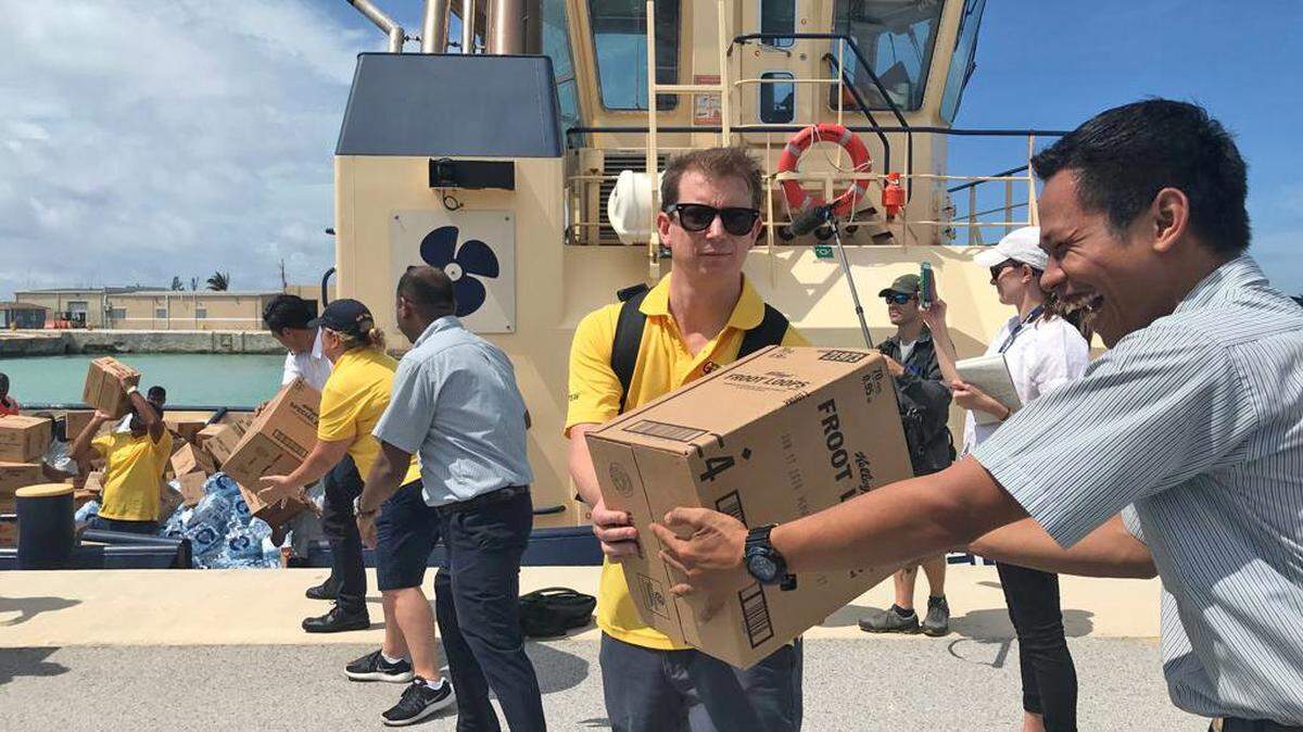Members of the Royal Caribbean GoTeam help download supplies from the Empress of the Seas cruise ship on the port at Freeport, Bahamas, on Thursday, September 5, 2019.