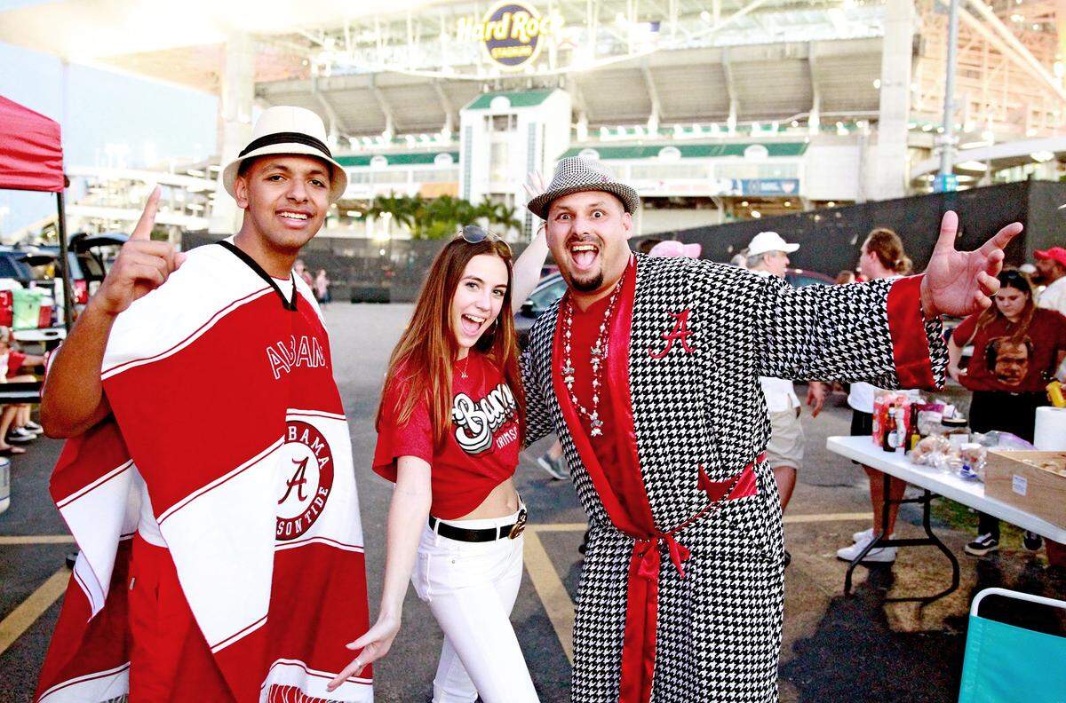 Alabama fans Isaac Phillips and Maverick Pemalle pose with a female fan as Alabama prepares to play Oklahoma in the College Football Playoff Semifinal at the Orange Bowl game at Hard Rock Stadium in Miami Gardens, Saturday, December, 29, 2018.