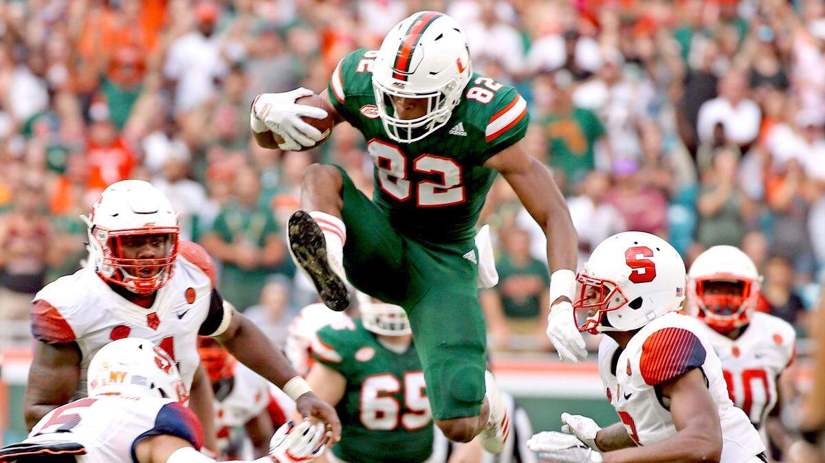 Miami Hurricanes Ahmmon Richards (82) catches a second quarter pass and leaps as the Syracuse University defense watches him at Hard Rock Stadium in Miami Gardens, Florida, Oct. 21, 2017.