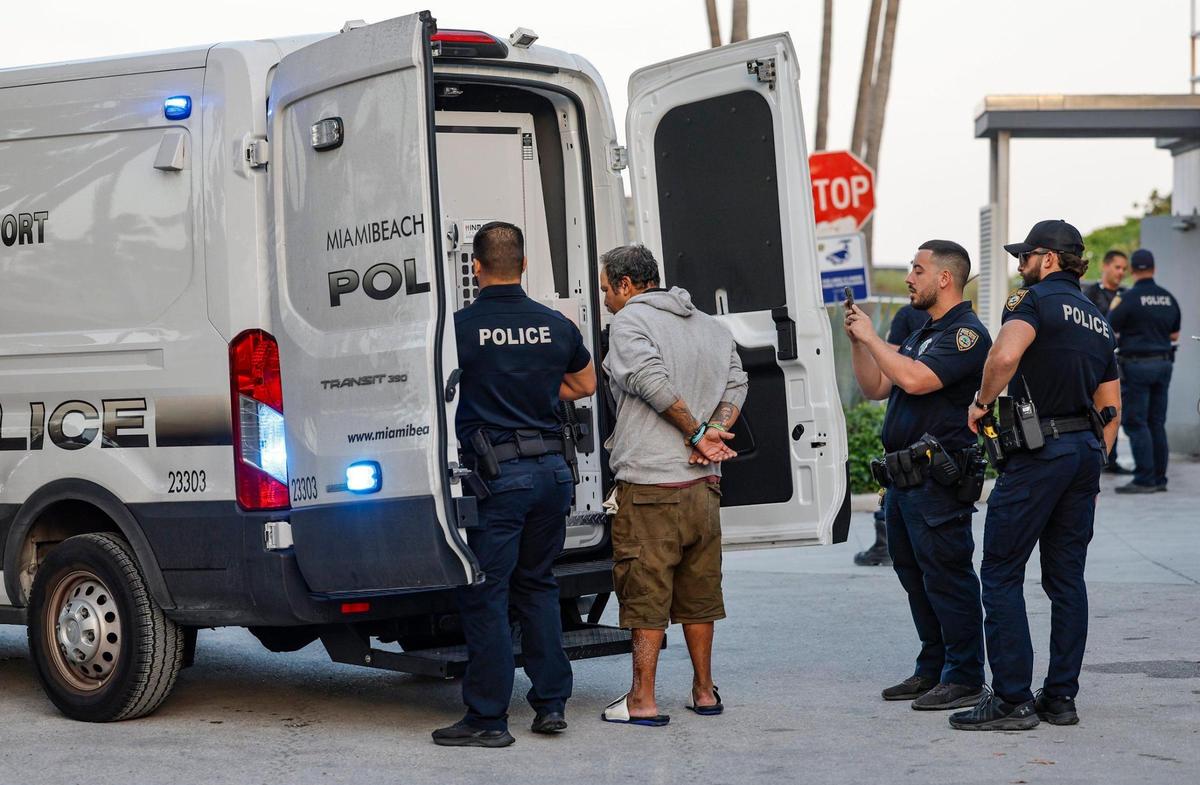 Miami Beach police officers detain a person along Ocean Drive during spring break on Miami Beach, Florida on Saturday, March 15, 2025.