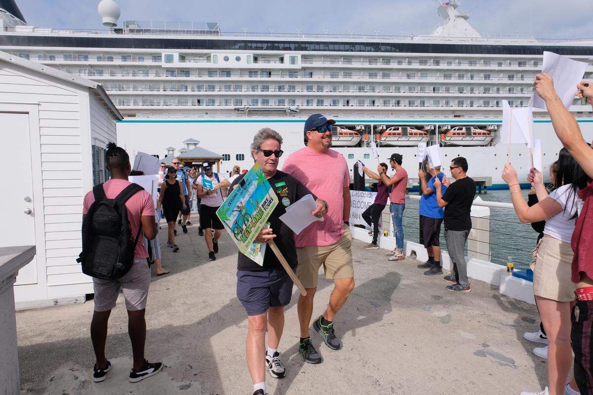 Christopher Ellis, holding a sign for his Key Lime Bike Tour business, helped welcome cruise ship passengers to Key West on Nov. 28, 2021.