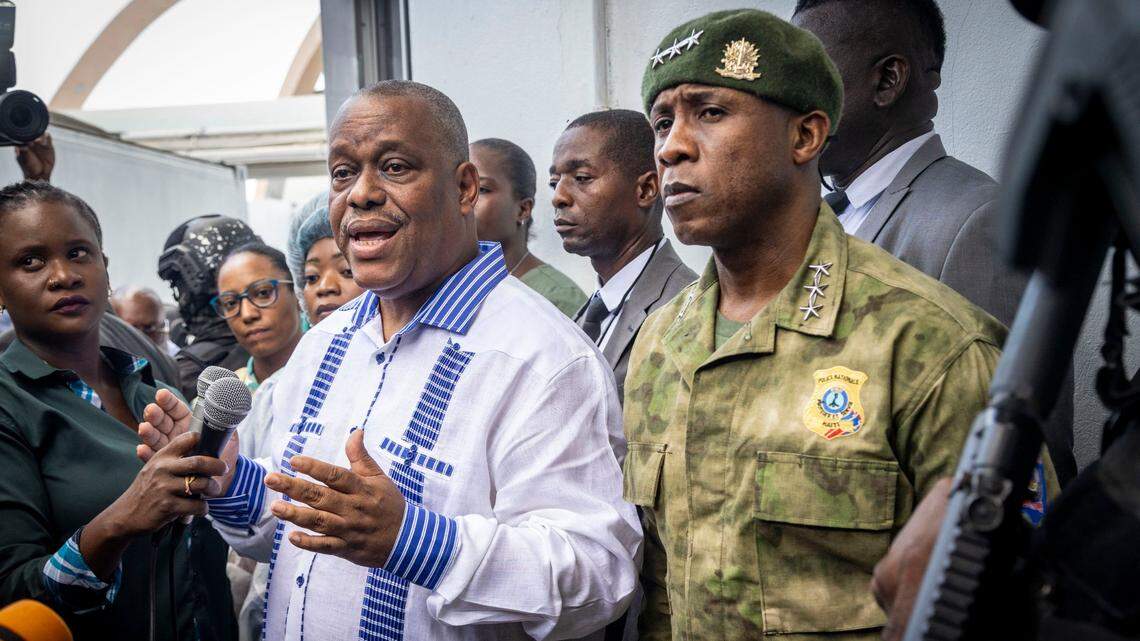 Haitian Prime Minister Gary Conille, left, speaks to the press along with Haiti Police Chief Rameau Normil, right, at Hospital Bernard Mevs where they went to visit Haitian police officers who have been wounded while battling gangs in Port-au-Prince.