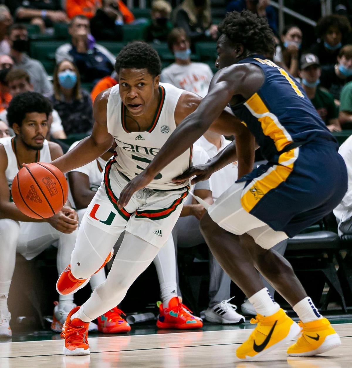 Miami Hurricanes guard Charlie Moore (3) tries to get past Canisius Golden Griffins guard Ahamadou Fofana (1) during the second half of an NCAA men’s basketball game at the Watsco Center in Coral Gables, Florida on Tuesday, November 9, 2021.