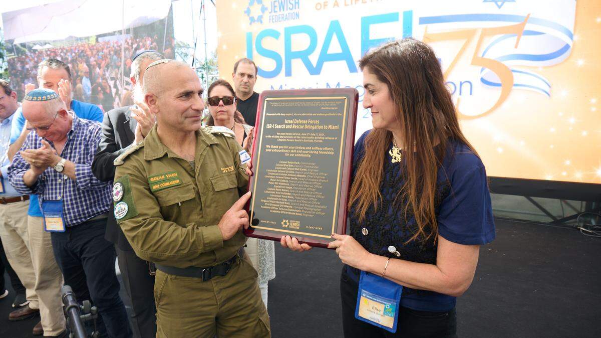 El coronel Golan Vach, quien dirige la famosa Unidad Nacional de Rescate de las Fuerzas de Defensa Israelíes, recibe una placa de manos de Elise Scheck Bonwitt, quien perdió a su familia en la tragedia de Surfside. Carlos Chattah Greater Jewish Miami Federation

