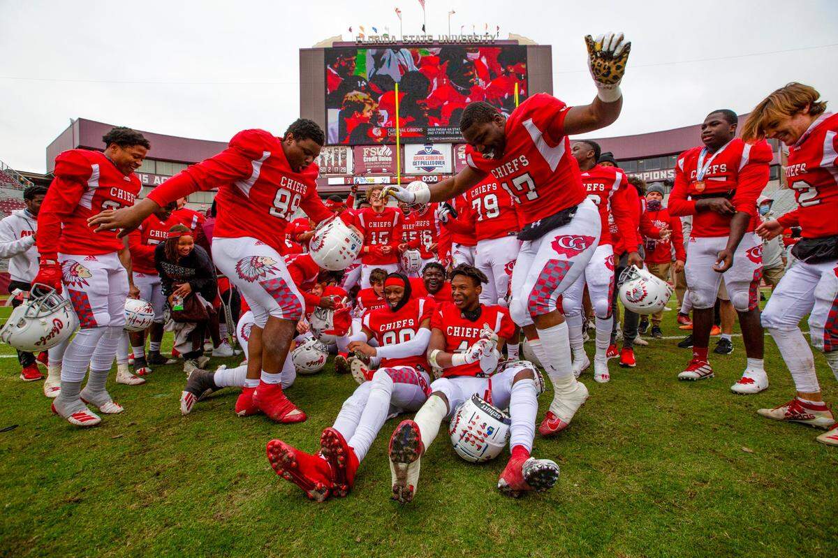 Cardinal Gibbons varsity football team celebrates in the middle of the field after defeating Jacksonville Bolles during the 4A State Championship at Doak Campbell Stadium in Tallahassee, Florida, on Thursday, December 17, 2020. The Chiefs were victorious over the Bulldogs 35-21.