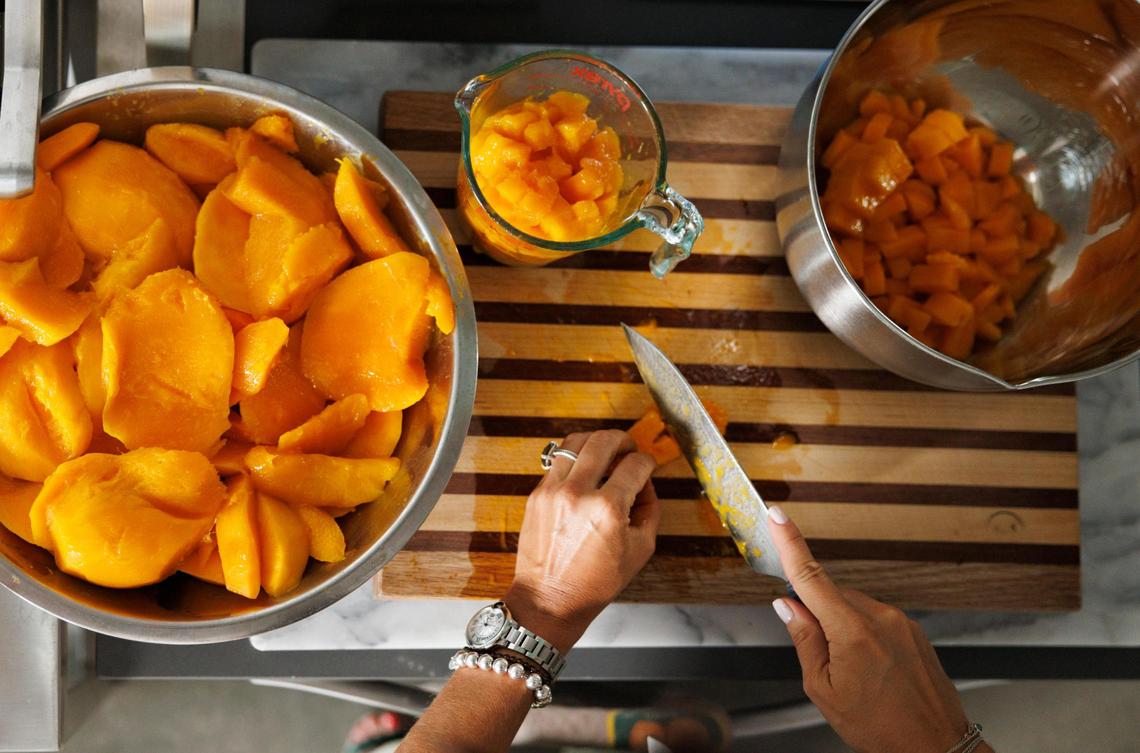 Natalia Martinez-Kalinina chops fresh mangoes at her Miami home.