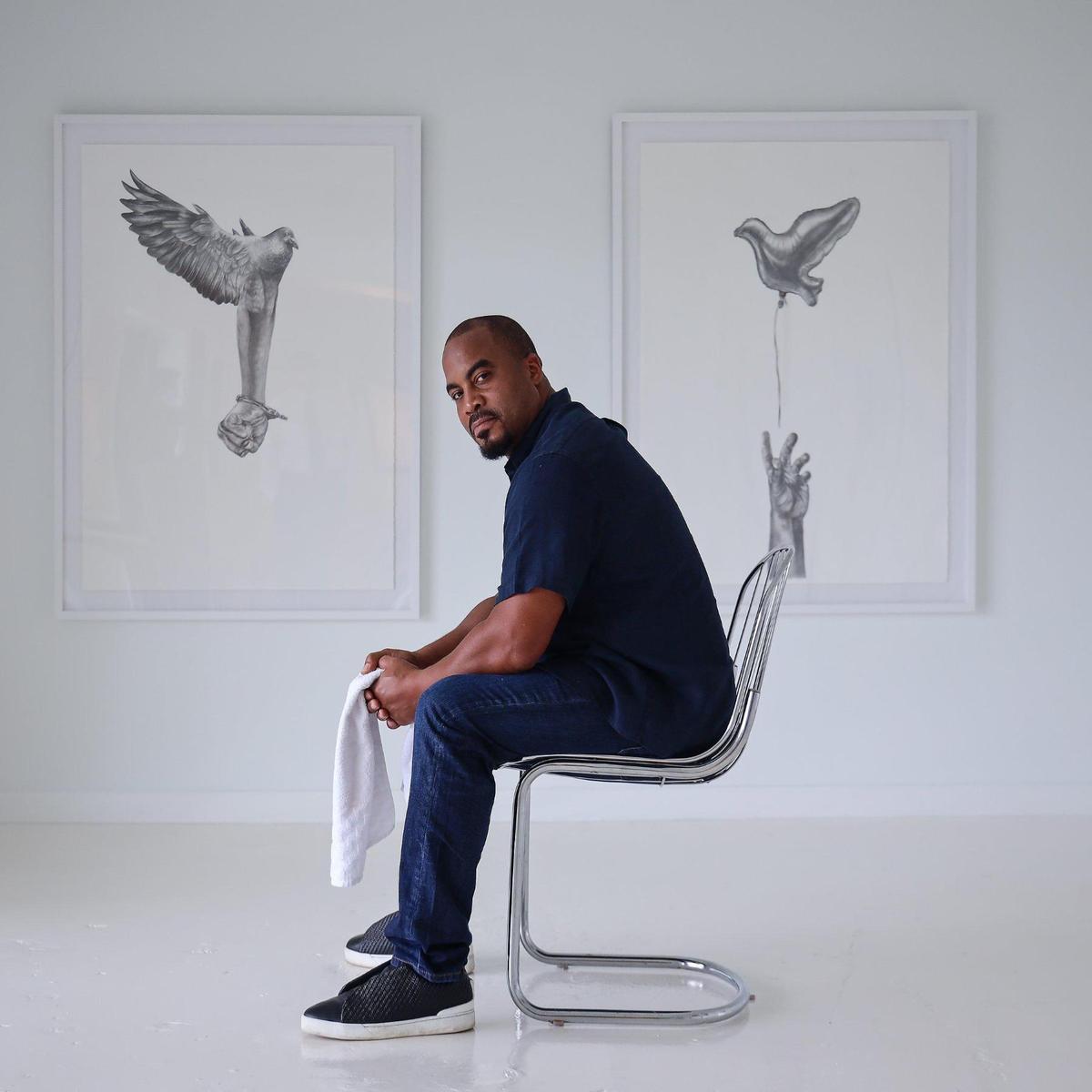 Jumaane N’Namdi is director of the Little Haiti gallery N’Namdi Contemporary Miami. While he thinks Art Basel’s cancelation is unfortunate, he said he’s looking forward to getting a break. Jumaane is photographed among Detroit artist Rashaun Rucker’s exhibition “Contemplation of Flight” show on Wednesday, November 25, 2020.h