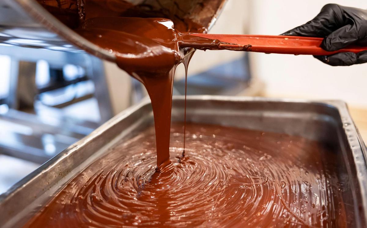 Carolina Quijano, founder of Exquisito Chocolates, empties her chocolate melanger at her new factory.