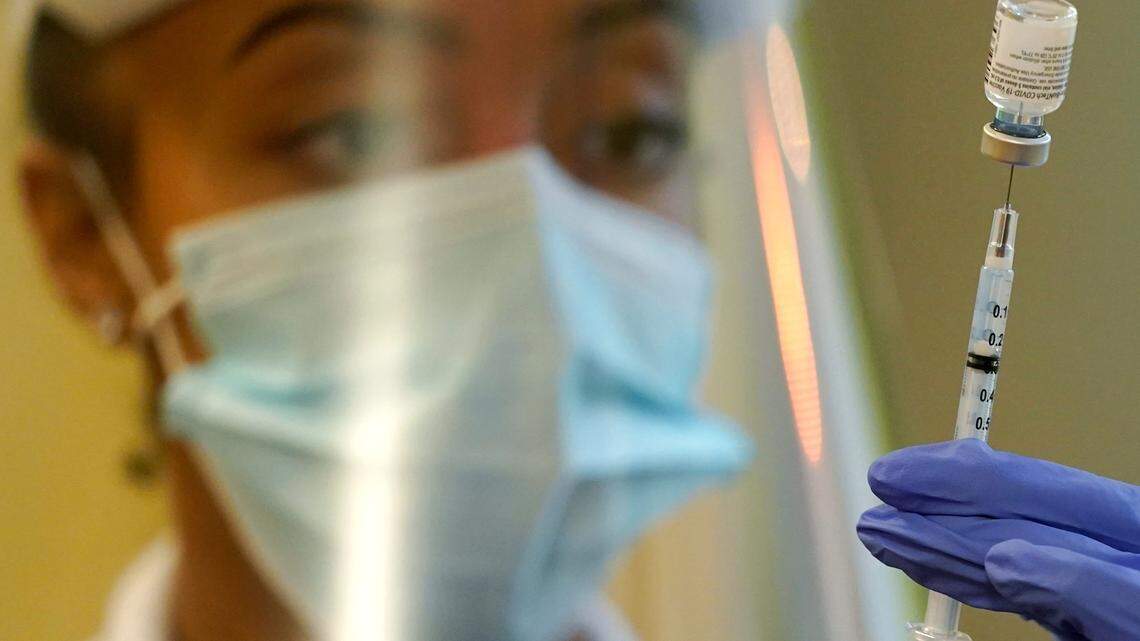A pharmacist prepares a syringe of the Pfizer vaccine for COVID-19, at Queen Anne Healthcare, a skilled nursing and rehabilitation facility in Seattle.