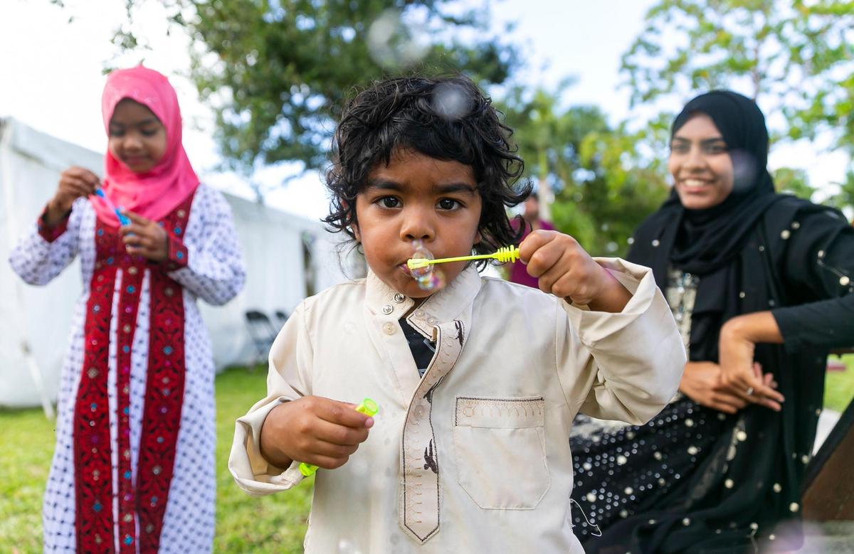 Ismaeel Ramjohn, 2, center, blows bubbles as he attends the Eid al-Adha prayer ceremony at the Islamic Center of Greater Miami on Saturday, July 9, 2022, in Miami Gardens, Fla.