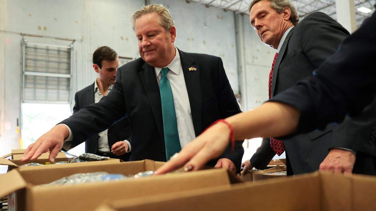 Mike Hammer, chargé d'affaires at the U.S. Embassy in Cuba, center, and the President and CEO of Catholic Relief Services Sean Callahan, right, pack relief supplies into a box to be delivered to victims of Hurricane Melissa in Cuba before a press conference at the Ecolog Warehouse, 1951 N. Commerce Parkway, Wednesday, Jan. 14, 2026, in Weston, Florida.