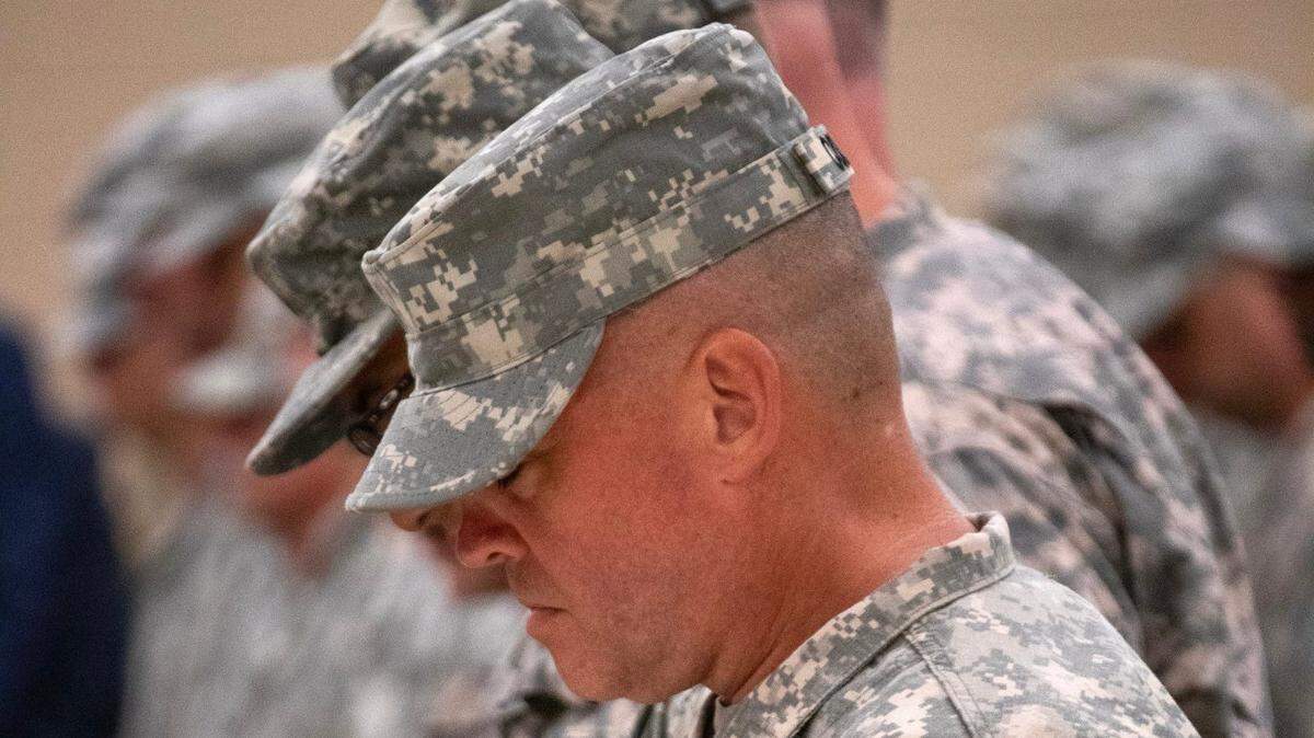 Florida State Guard members bow their heads in prayer during the Florida State Guard graduation ceremony at Camp Blanding Joint Training Center in Starke, Fla., June 30, 2023.