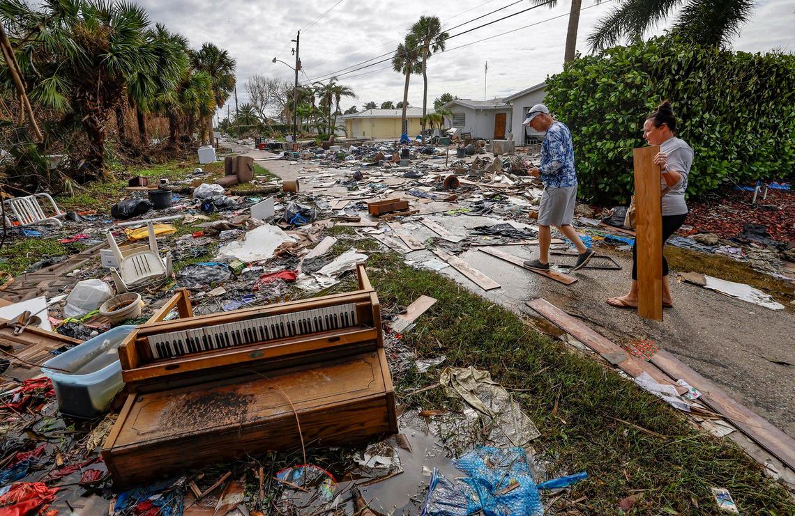 Karre Willis, right, and her husband walk through their neighborhood surveying damage and debris in front of their neighbors’ homes in Charlotte County near Manasota Key on Thursday, Oct. 10, 2024, the morning after Hurricane Milton hit the area.