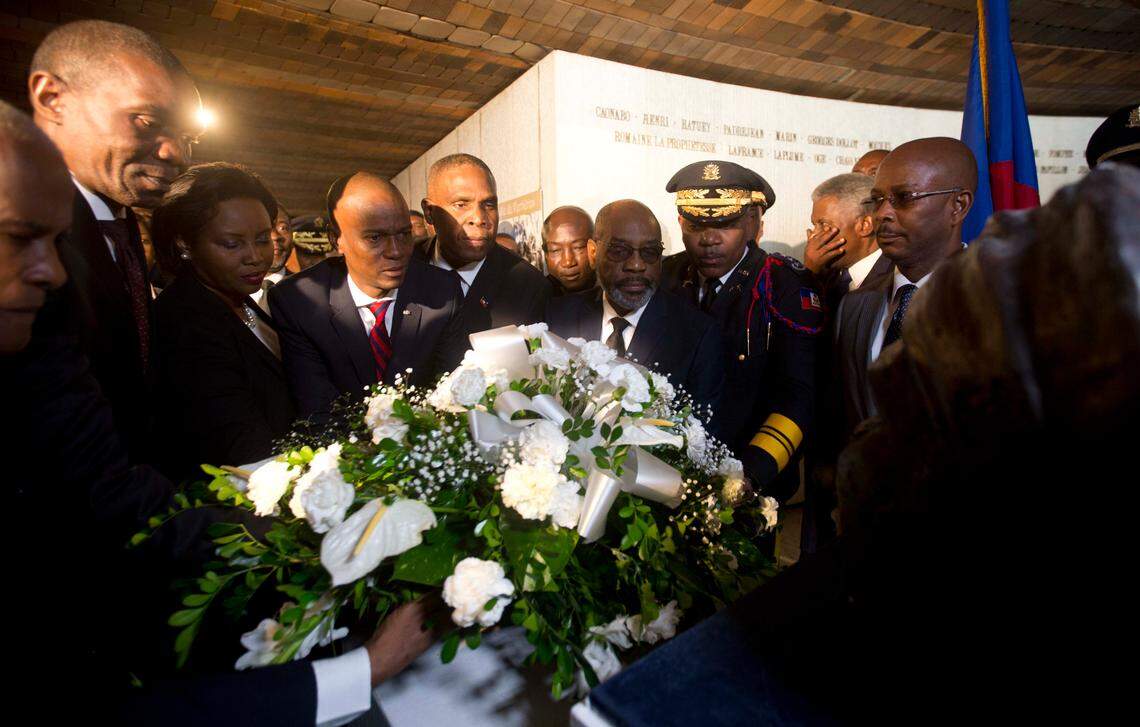 Haiti’s President Jovenel Moise, center left, places flowers in front of a monument during a ceremony marking the 215th anniversary of Battle of Vertieres in Port-au-Prince, Haiti, Sunday, Nov. 18, 2018. The battle was the last major fight for Haitian independence from the French. (AP Photo/Dieu Nalio Chery)
