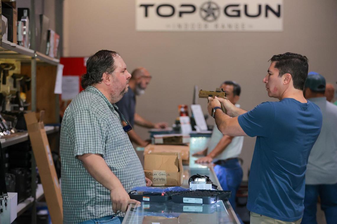 Top Gun Indoor Range Sales Specialist Adolfo Dominguez, left, talks to a client at 12015 SW 114 Pl.. in Kendall on Friday, July 18, 2025.