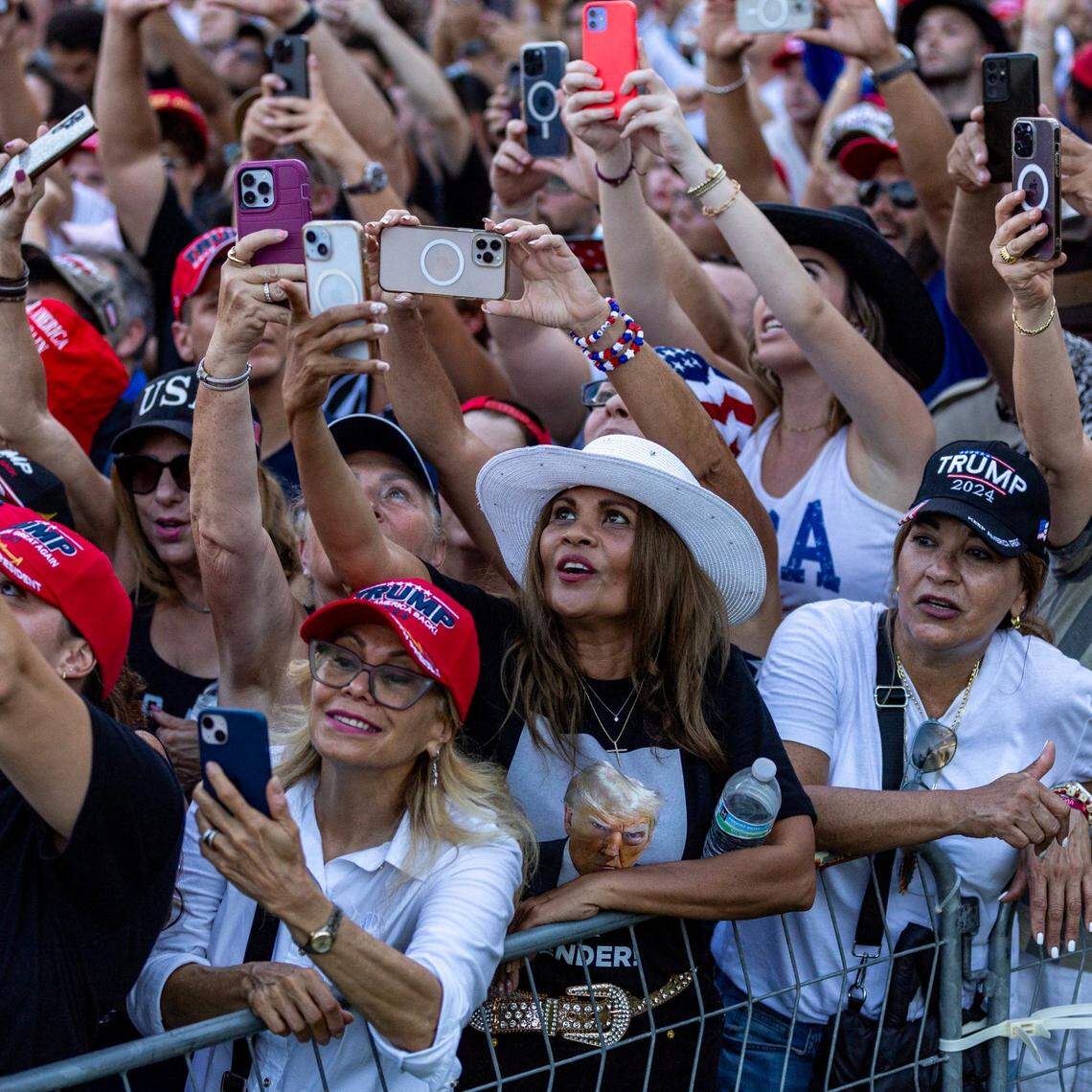 Trump supporters try to get videos of former President Donald Trump speaking during a rally at Trump National on Tuesday, July 9, 2024, in Doral, Fla.