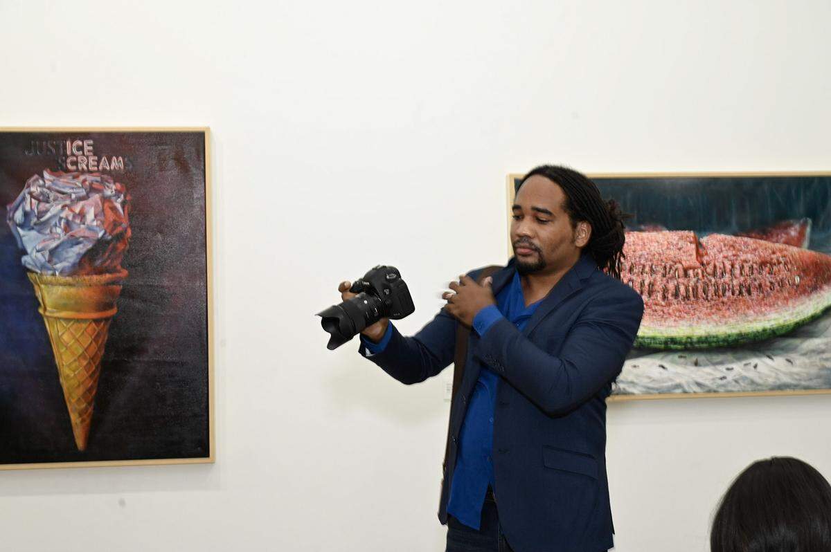 Jamaican artist Michael Elliott in front of his pieces “Sundae Morning” and “Seeds of the Tide (Clotilda)” at Green Space Miami. His artwork deals with the legacy of slavery and racism.