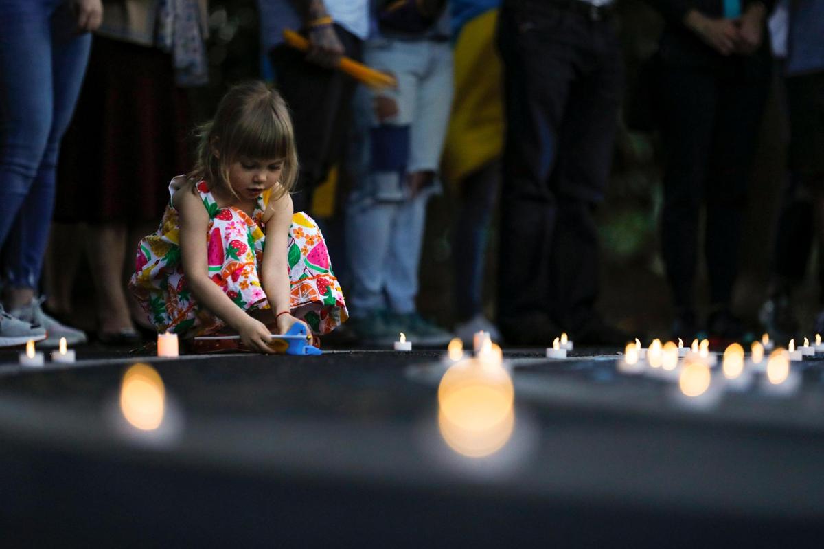 Olivia Sibiriakova, 4, plays with artificial candles during a rally and vigil in support of Ukrainians affected by the Russian invasion of Ukraine at St Nicholas Ukrainian Orthodox Church in Cooper City.