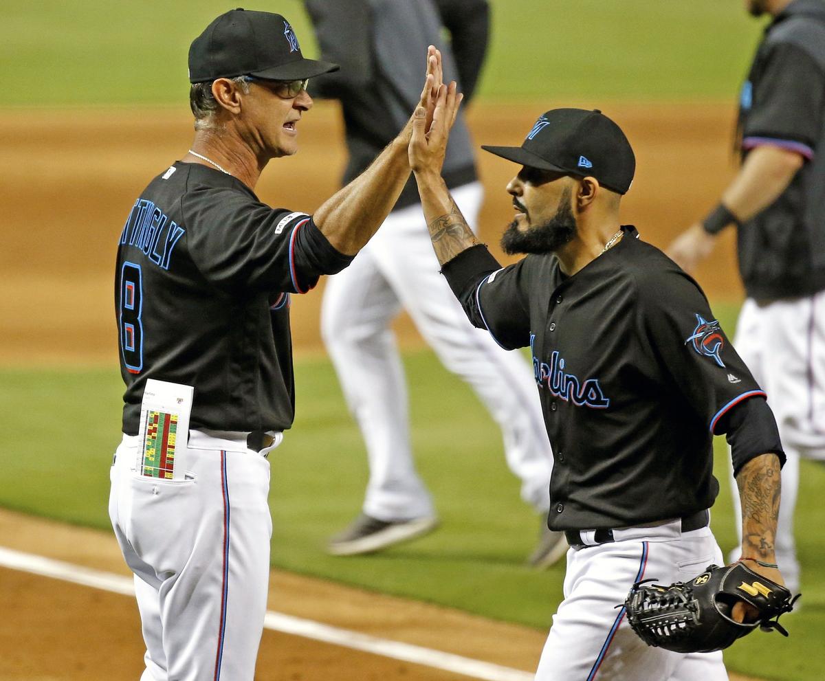 Miami Marlins relief pitcher Sergio Romo (54) high fives Miami Marlins manager Don Mattingly (8) after a double play ends the ninth inning as the Miami Marlins defeat the Pittsburgh Pirates at Marlins Park on Saturday, June 15, 2019.
