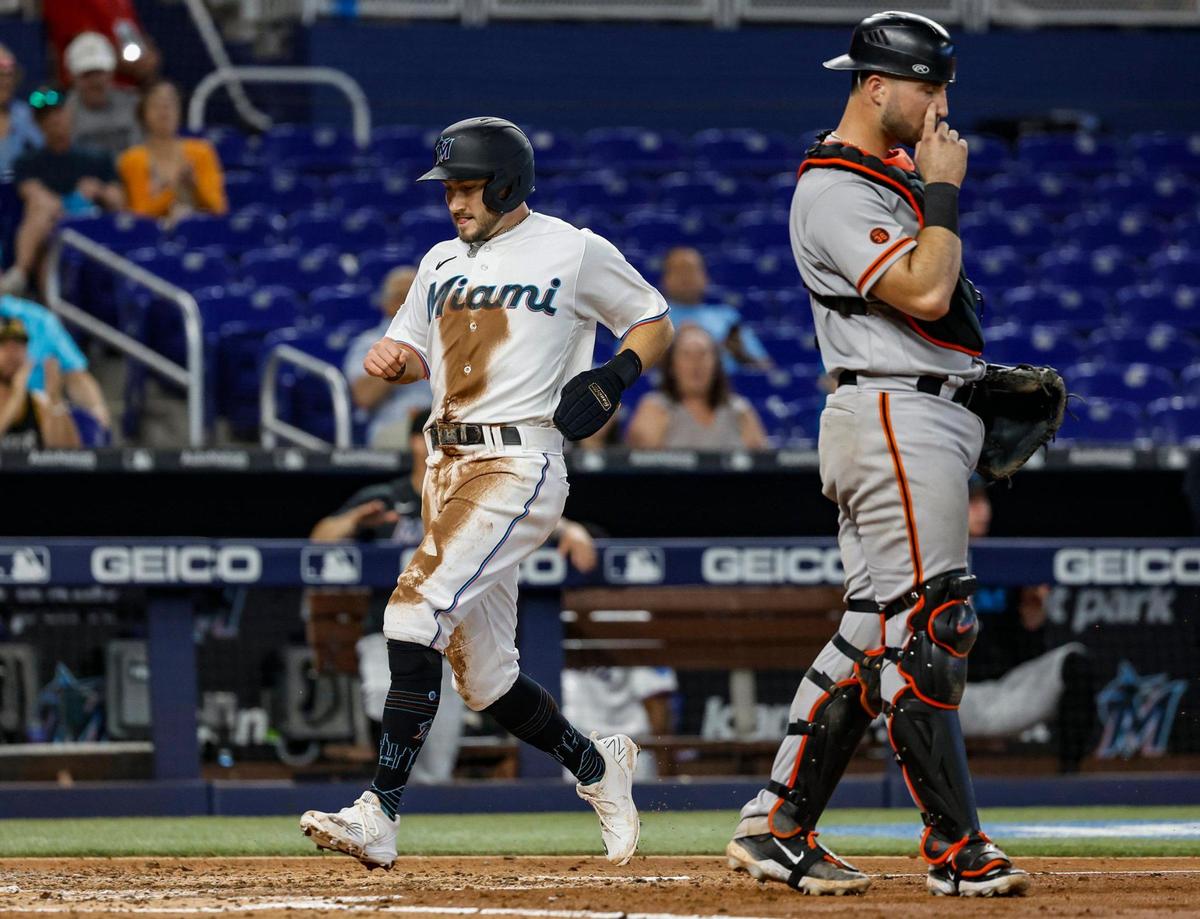 Miami Marlins shortstop Garrett Hampson (1) scores as San Francisco Giants catcher Joey Bart (21) reacts after Garrett Cooper (26) singles on a ground ball to left field in the fourth inning at LoanDepot Park in Miami, Fl on Wednesday, April 19, 2023. Garrett Cooper singles on a ground ball to left fielder Heliot Ramos. Garrett Hampson scores.