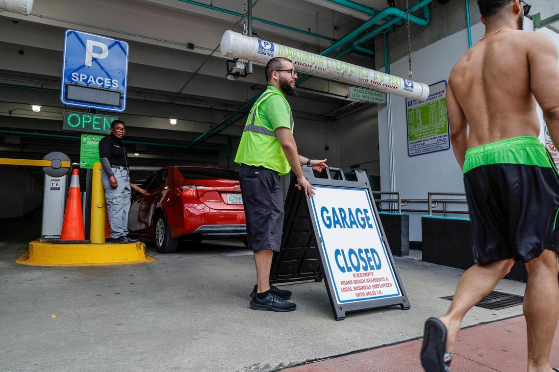 Parking workers stand watch after a city garage is closed during spring break in 2024.