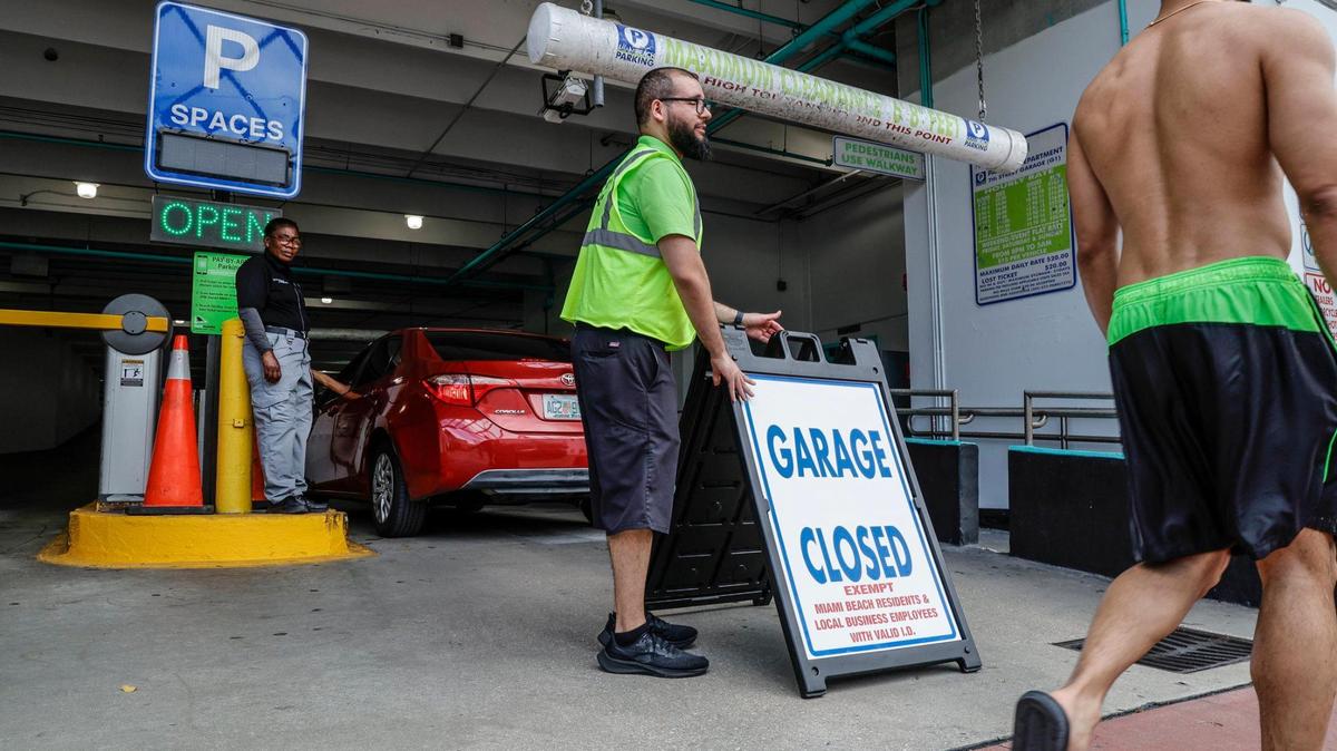 Parking attendent Jorge Latil and security guard Yvane Saint Jean stand watch after City Garage 1 is closed to everyone except Miami Beach residents and local business employees on Thursday, March 7, 2024. Most public parking garages and lots south of 42nd Street will be entirely closed this weekend for spring break in Miami Beach, Florida.