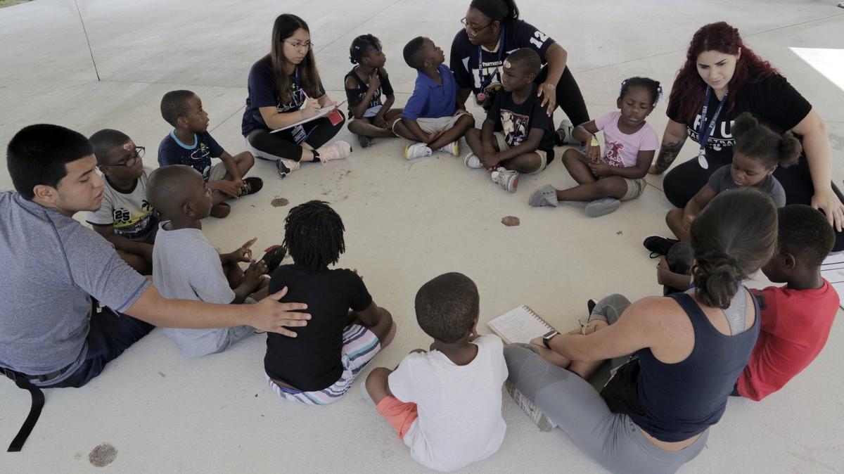 Counselors talk to campers to give them instructions before going to the field to play soccer at the FIU Summer Academy in Miami on July 24, 2018.