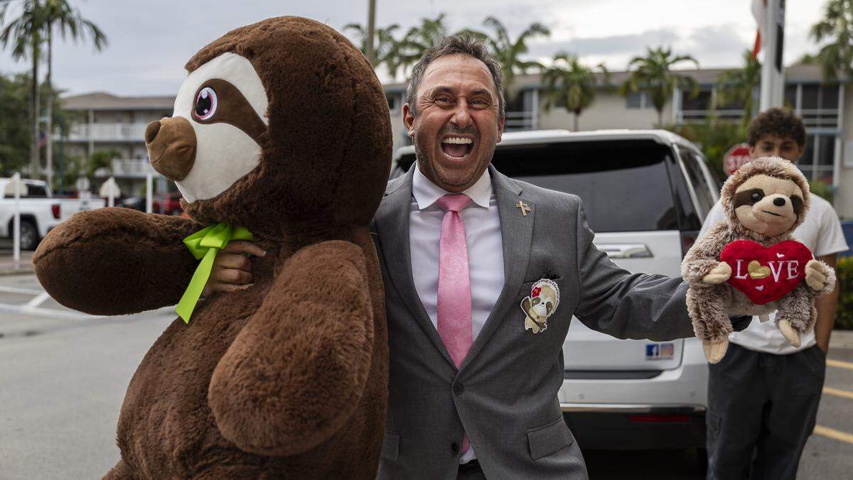 Commissioner Tommy Ruzzano reacts while holding stuffed sloths as he arrives at Margate City Hall ahead of a commission meeting on Wednesday, June 3, 2026, in Margate, Fla. Protestors gathered at City Hall in opposition to Larry Wallach's pending application to open a sloth encounter business in Margate.