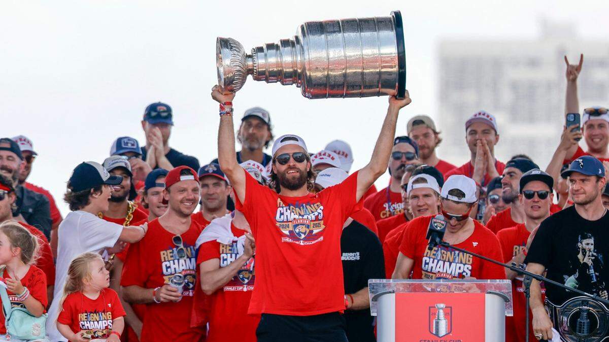 Florida Panthers defenseman Aaron Ekblad hoists the Stanley Cup as teammates cheer on stage during the team’s Stanley Cup victory parade and rally along A1A in Fort Lauderdale, Florida, on Sunday, June 22, 2025.