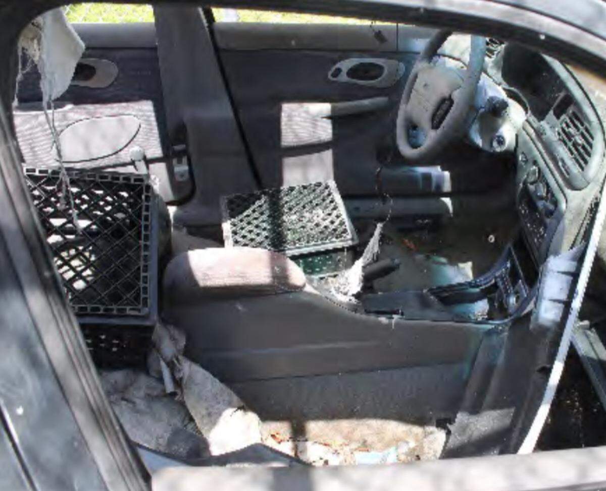 A milk crate rests where the front driver’s seat of a car should be. The vehicle is part of a fleet of dilapidated cars belonging to the Miami-Dade County Public Schools driver education program.