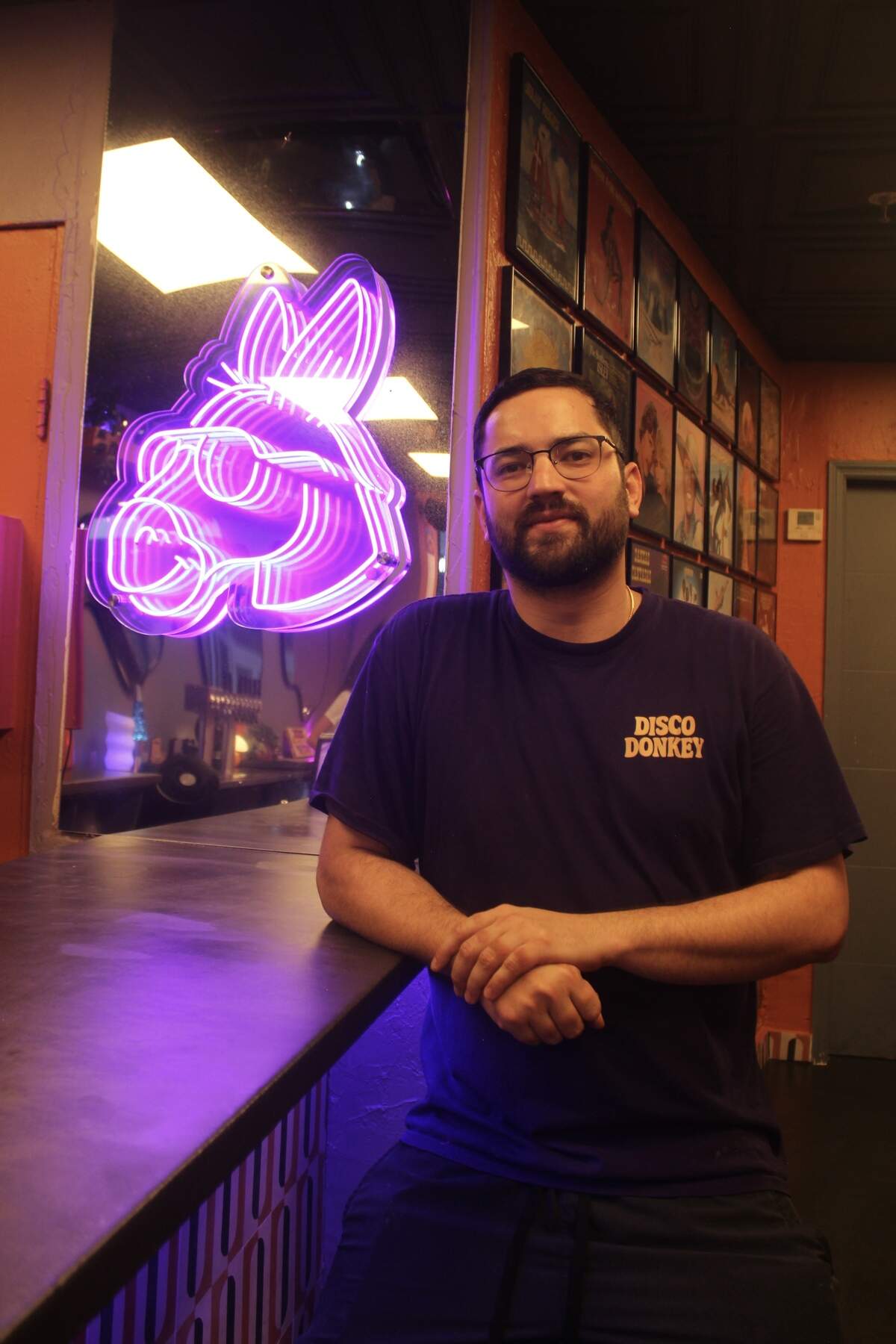 Chef Leo Soto poses by an LED sign of a donkey with sunglasses at Disco Donkey on July 1, 2026.