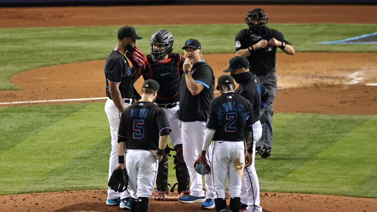 Miami Marlins pitcher Sandy Alcantara (22) and Jorge Alfaro (38) talk with pitching coach Mel Stottlemyre Jr after a play during the third inning of their baseball game against the Atlanta Braves at loanDepot park on Friday, June 11, 2021 in Miami, Florida.