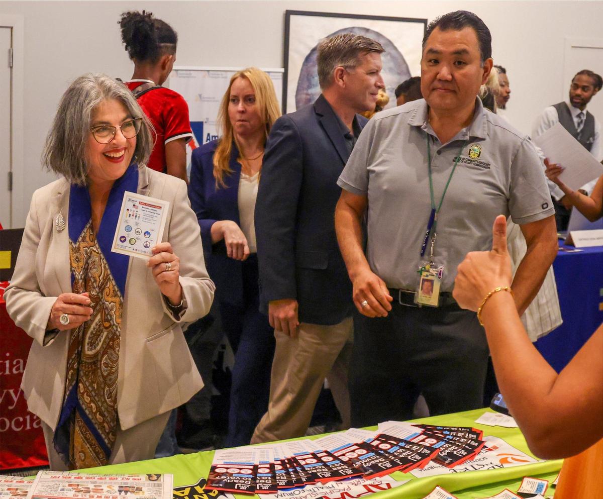 Miami-Dade Mayor Daniella Levine Cava, left, smiles as she visits another service provider during the Miami-Dade County Community Action and Human Services Department’s Office of New Americans’ Day of Welcome to honor the contributions of immigrants on Wednesday, September 18, 2024, at the Miami-Dade County Main Library in Miami, Florida.