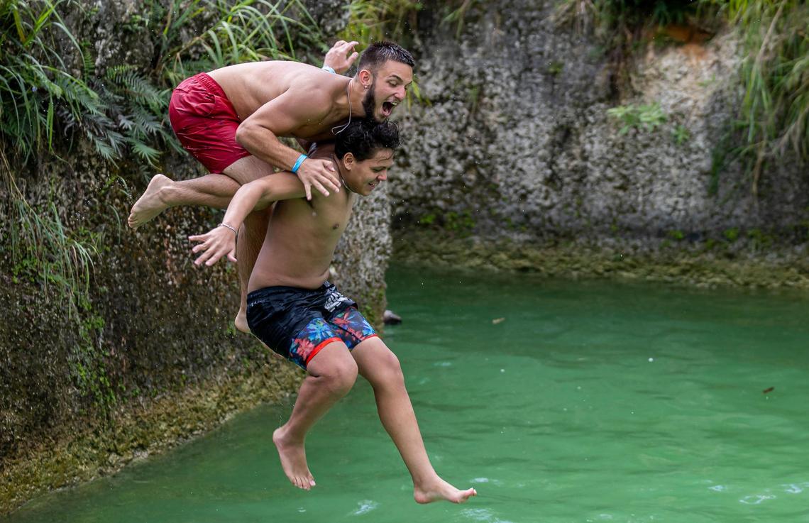 Addiel Gil, 18, left, and Angel Garcia, 18, jump into a pool at Blue Lagoon Farm Miami.